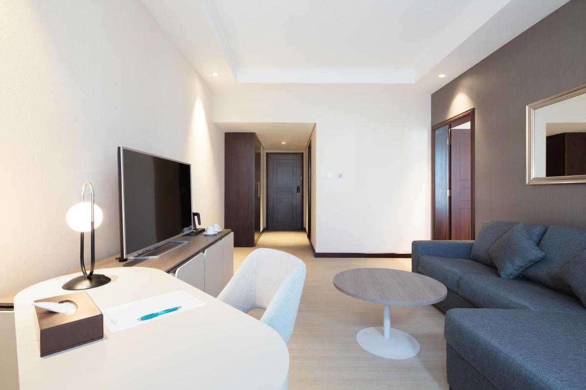 a living room with a couch and a table at Barcelo Al Jaddaf, Dubai in Dubai