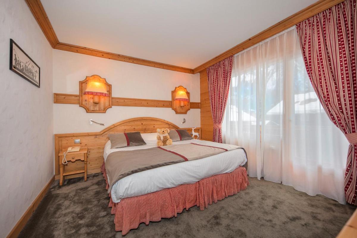 Un ou plusieurs lits dans un hébergement de l'établissement Chalet-Hôtel Neige et Roc, The Originals Relais