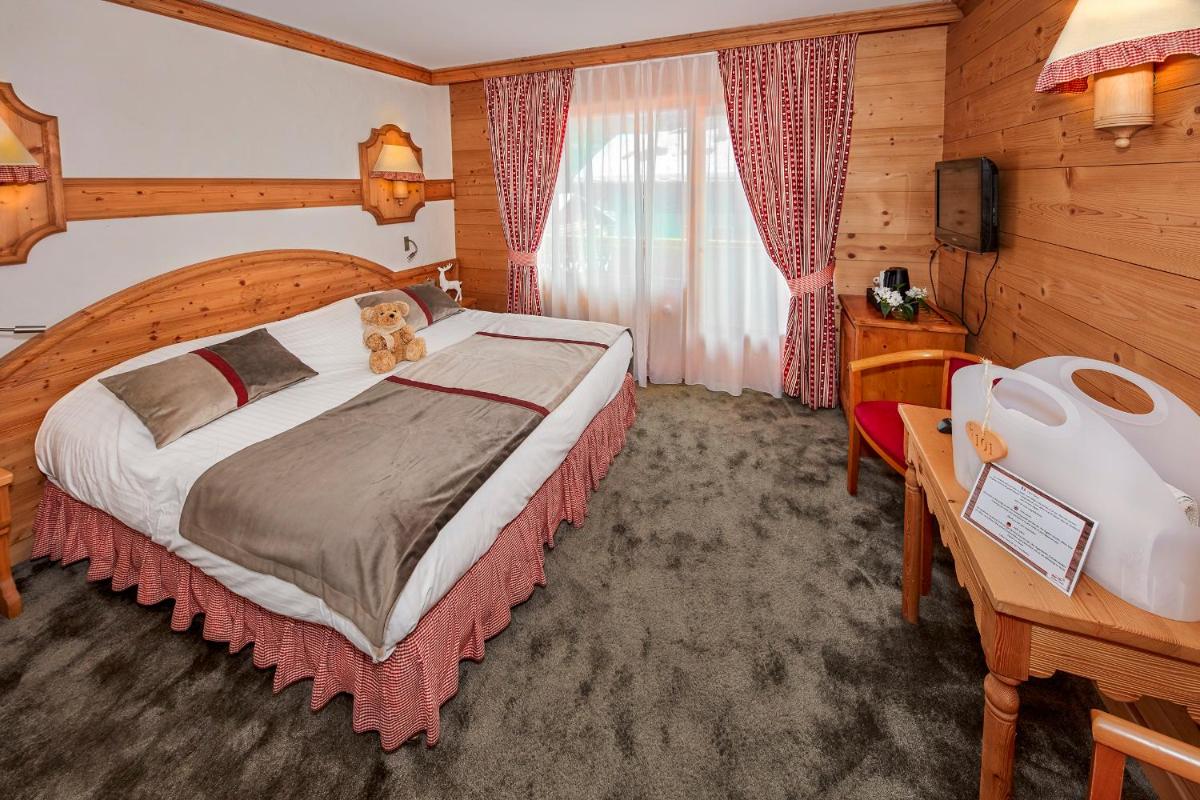 Un ou plusieurs lits dans un hébergement de l'établissement Chalet-Hôtel Neige et Roc, The Originals Relais