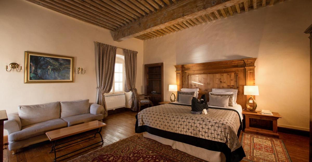 une chambre avec un lit sur lequel un chat est assis dans l'établissement Abbaye de Talloires, à Talloires