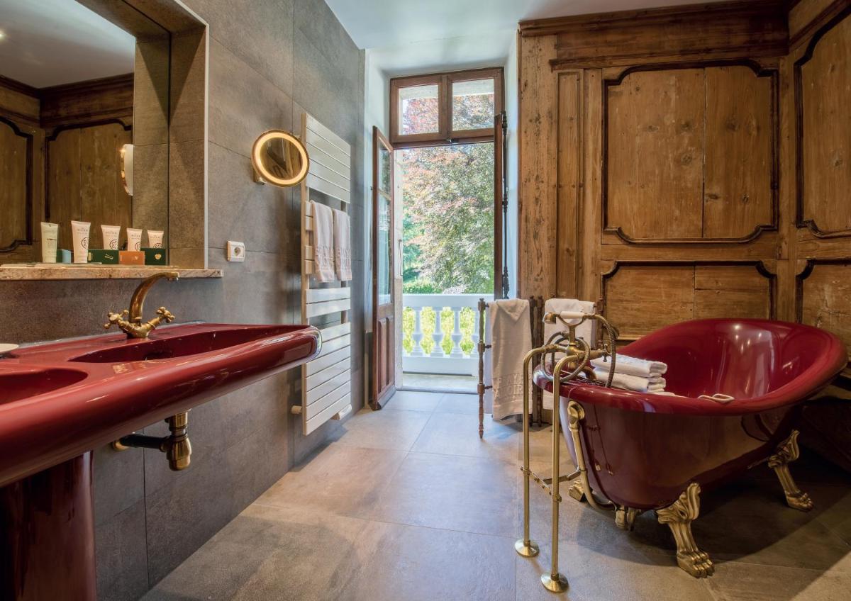 une salle de bains avec une baignoire rouge et un lavabo dans l'établissement Abbaye de Talloires, à Talloires