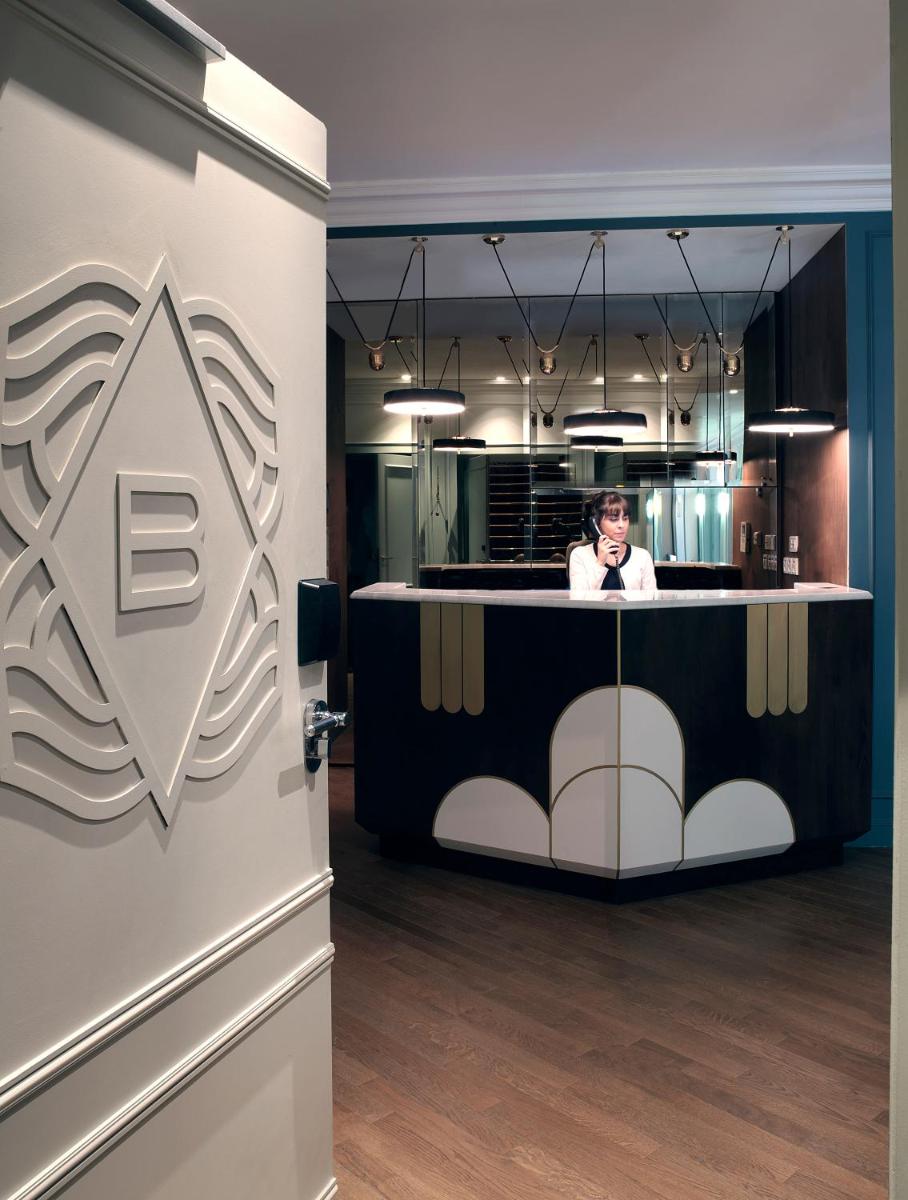 une femme est assise à une table dans une pièce dans l'établissement Hotel Bachaumont, à Paris