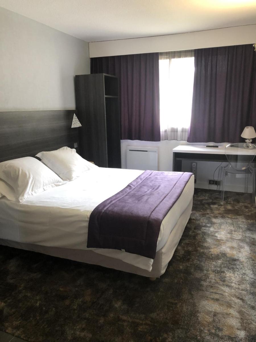 Un ou plusieurs lits dans un hébergement de l'établissement Logis Hotel Restaurant SPA Les Oliviers