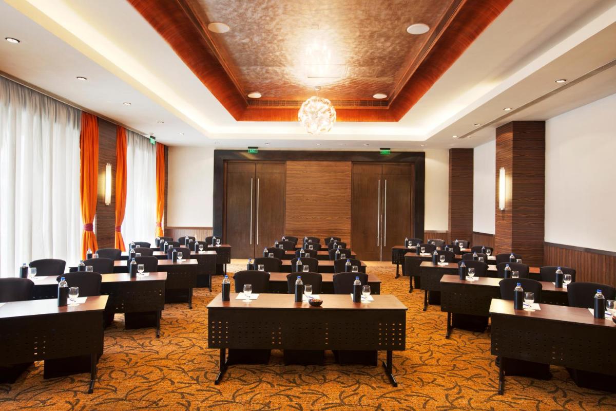 a conference room with tables and chairs and a podium at Novotel Mumbai Juhu Beach in Mumbai