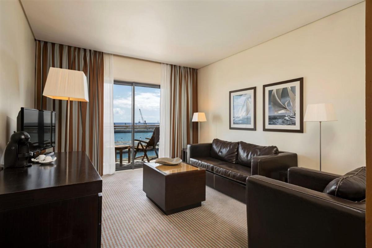 uma sala de estar com um sofá e uma televisão em Hotel Marina Atlântico em Ponta Delgada