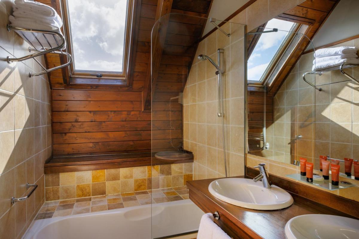 Un baño con lavabo, bañera y ducha. en Snö Aragon Hills, en Formigal