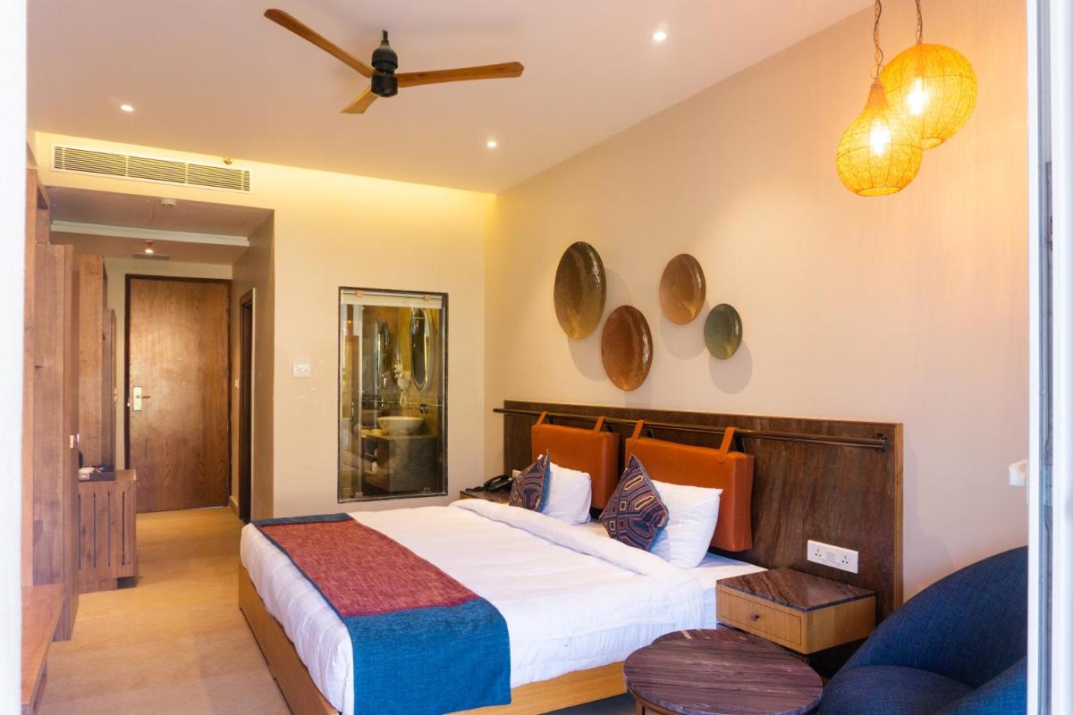 a bedroom with a bed and a ceiling fan at Antalya By Divine Ganga Cottage in Rishīkesh