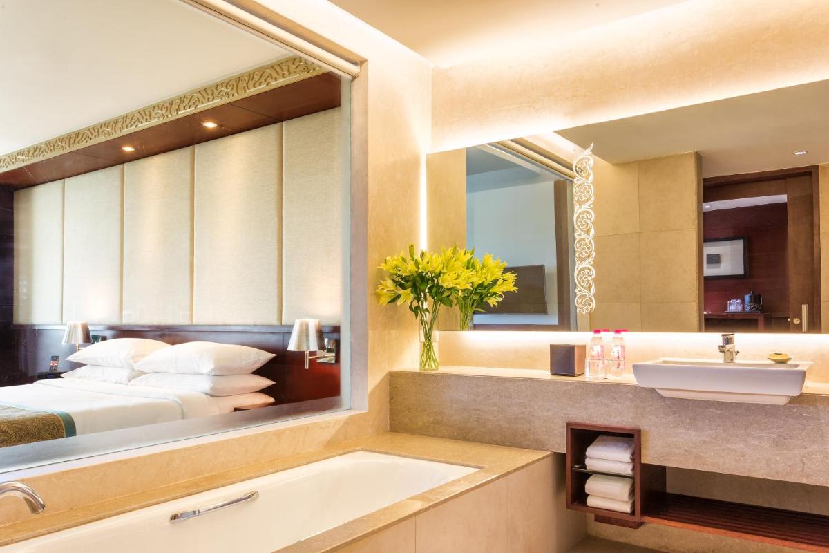 a bathroom with a bed and a sink and a tub at Crowne Plaza Ahmedabad City Centre by IHG in Ahmedabad