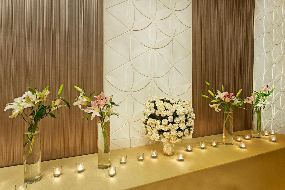 a table with vases filled with flowers and candles at Crowne Plaza Ahmedabad City Centre by IHG in Ahmedabad