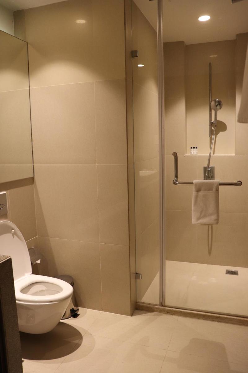 a bathroom with a toilet and a glass shower at Oakwood Residence Kapil Hyderabad in Hyderabad