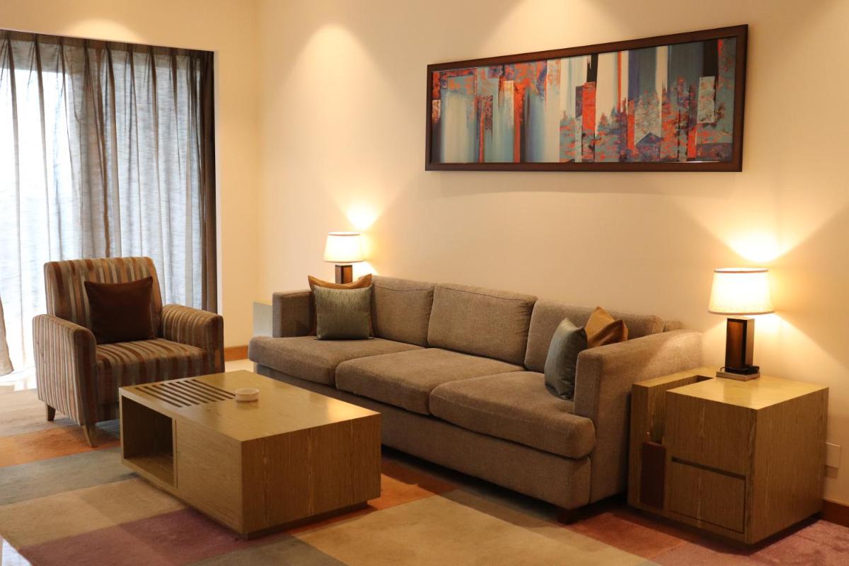 a living room with a couch and a chair at Oakwood Residence Kapil Hyderabad in Hyderabad