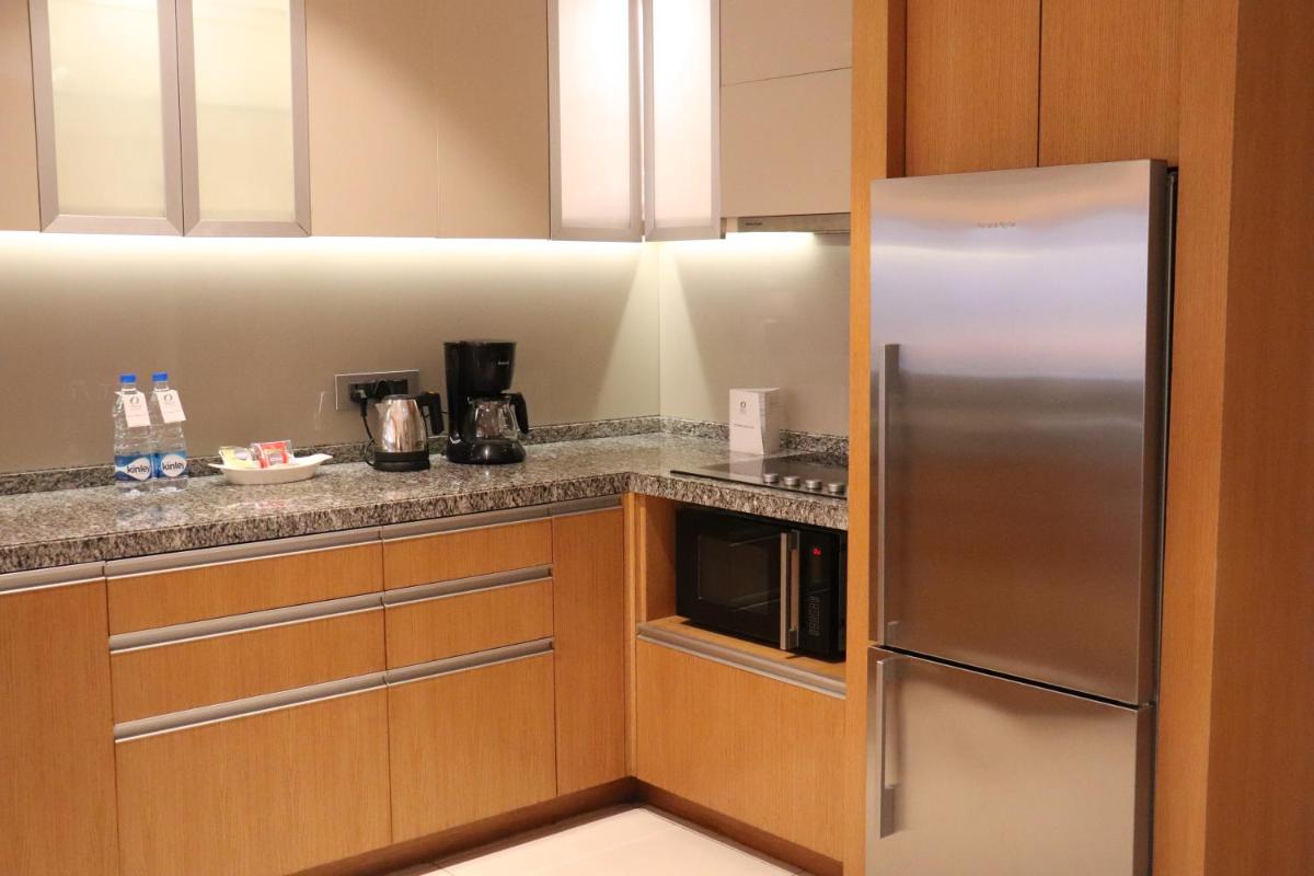 a kitchen with a stainless steel refrigerator at Oakwood Residence Kapil Hyderabad in Hyderabad