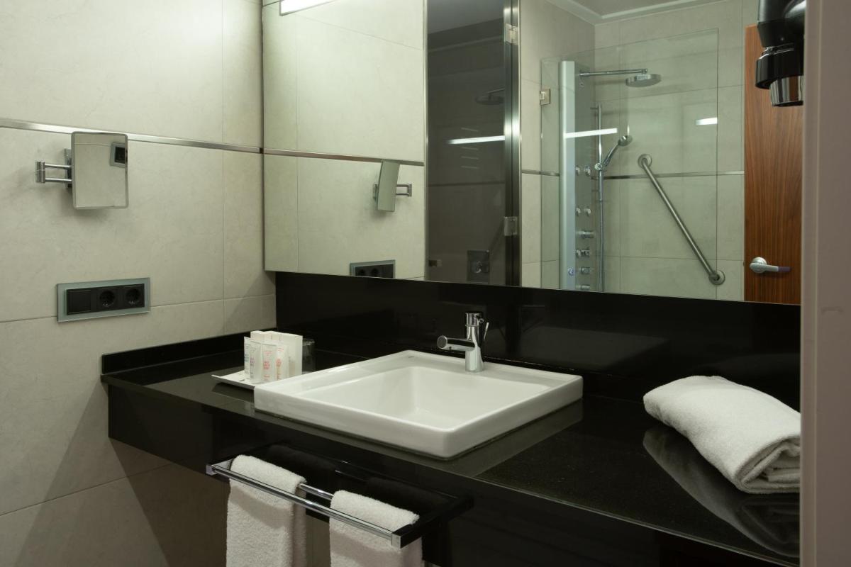un baño con lavabo y espejo en Primus Valencia, en Valencia