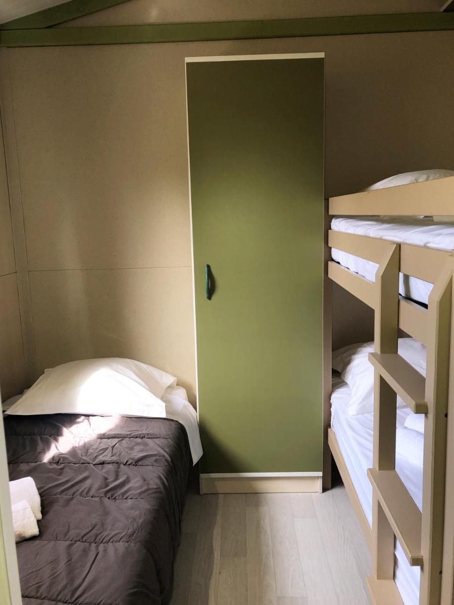Un ou plusieurs lits dans un hébergement de l'établissement Camping La Pinède