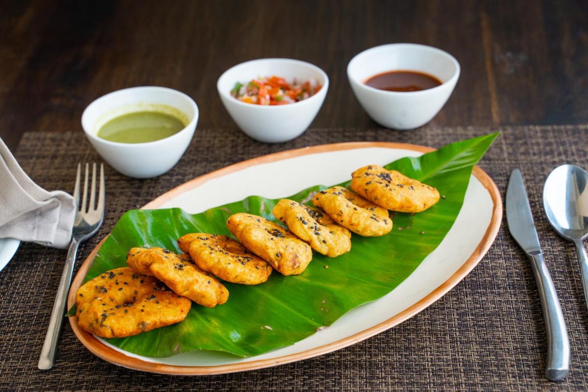 a plate of food on a table with a plate of food at Antalya By Divine Ganga Cottage in Rishīkesh