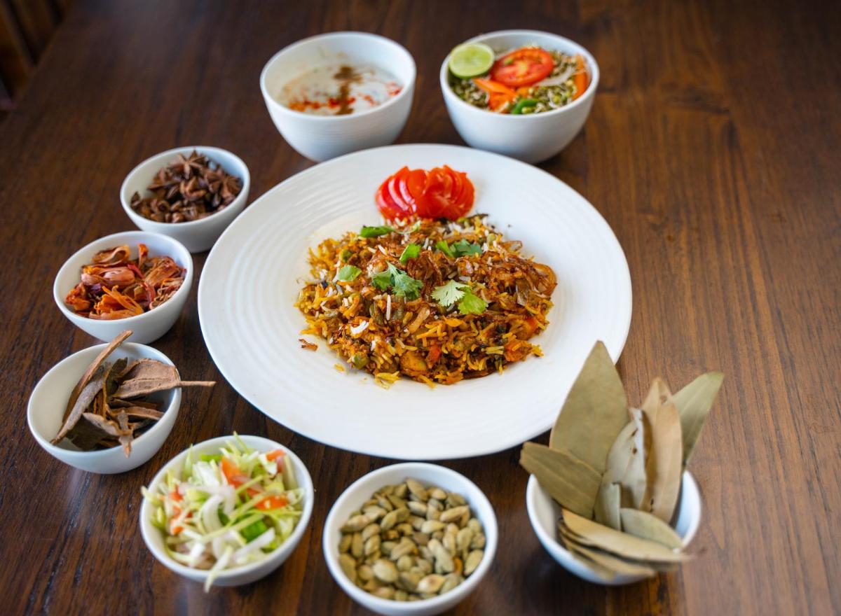 a table with plates of food and bowls of different foods at Antalya By Divine Ganga Cottage in Rishīkesh