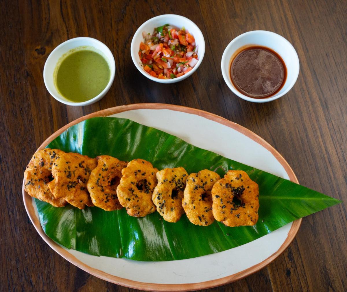 a plate of food on a wooden table with food at Antalya By Divine Ganga Cottage in Rishīkesh