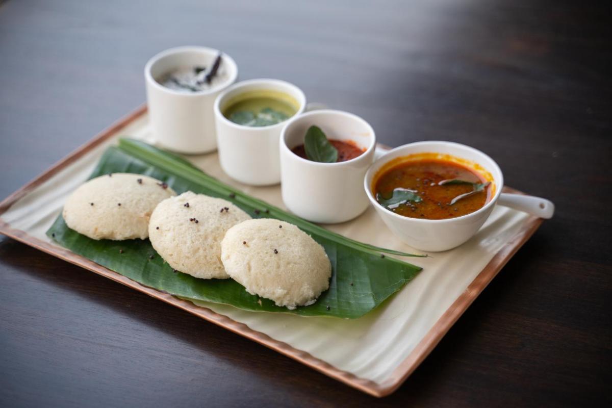 a plate of food with biscuits and dipping sauces at Antalya By Divine Ganga Cottage in Rishīkesh