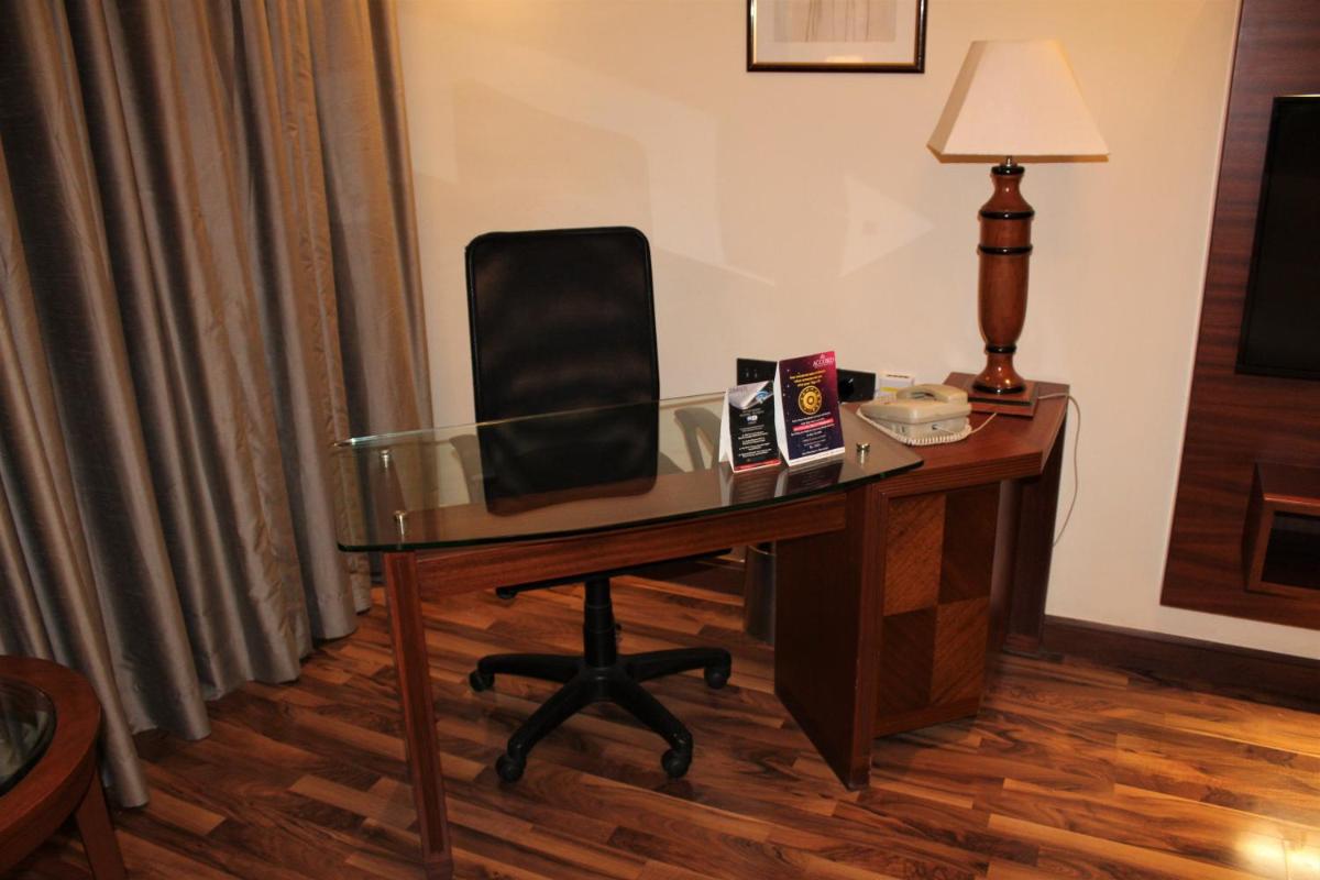 a desk with a chair and a lamp in a hotel room at The Accord Metropolitan in Chennai