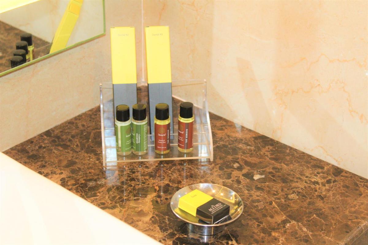 a glass vase with four bottles on a counter at The Accord Metropolitan in Chennai