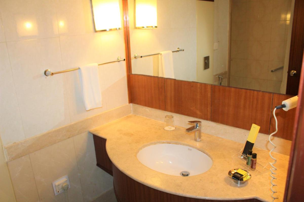 a bathroom with a sink and a mirror at The Accord Metropolitan in Chennai