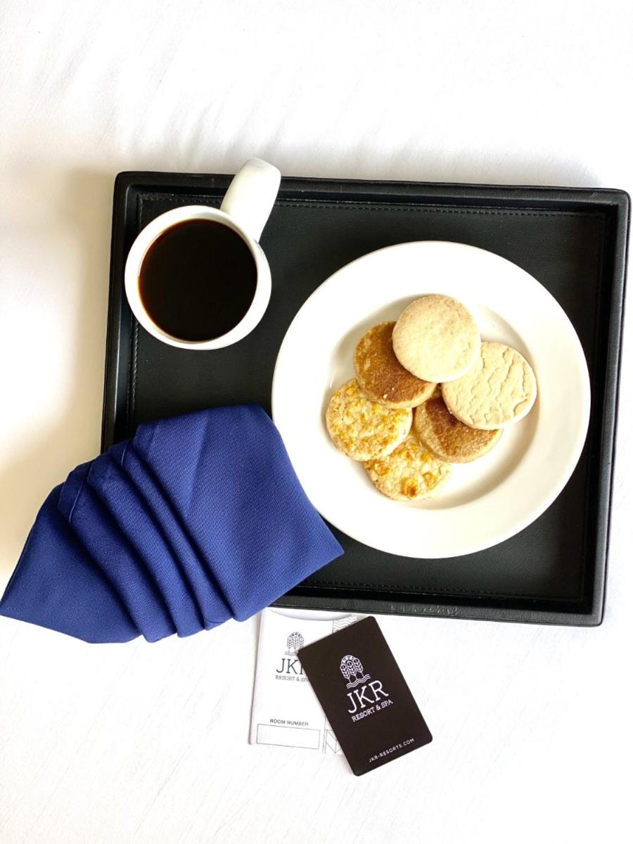 a tray with a plate of cookies and a cup of coffee at The Residency Towers, Rameswaram in Rāmeswaram