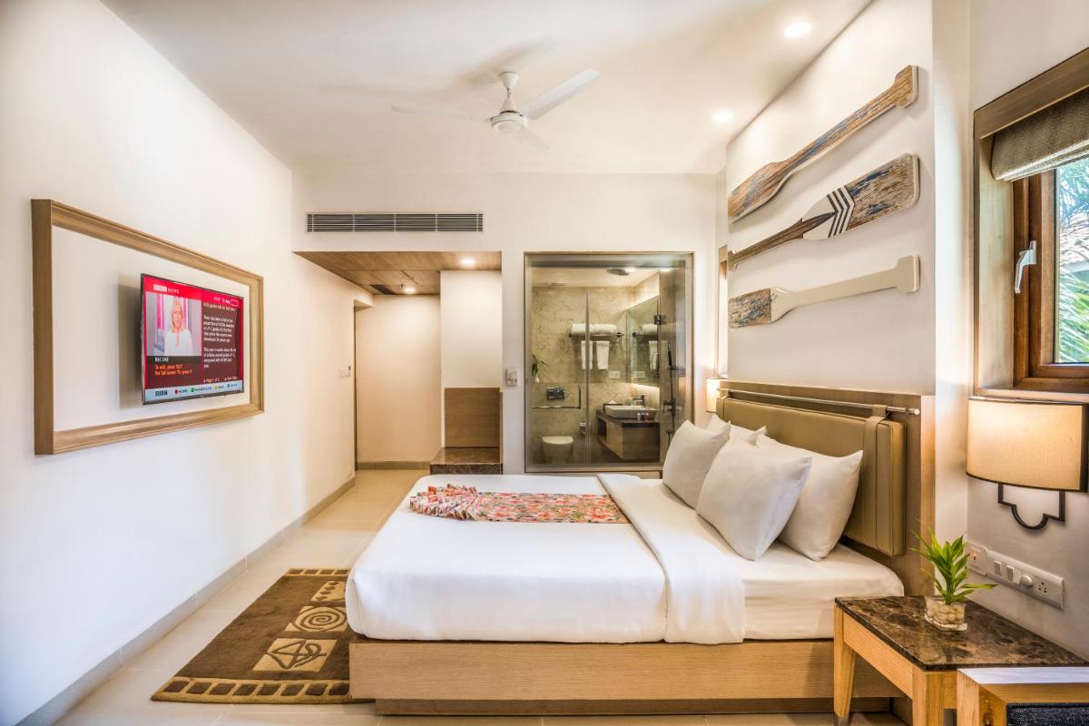 a bedroom with a large bed and a bathroom at Radisson Goa Candolim in Candolim