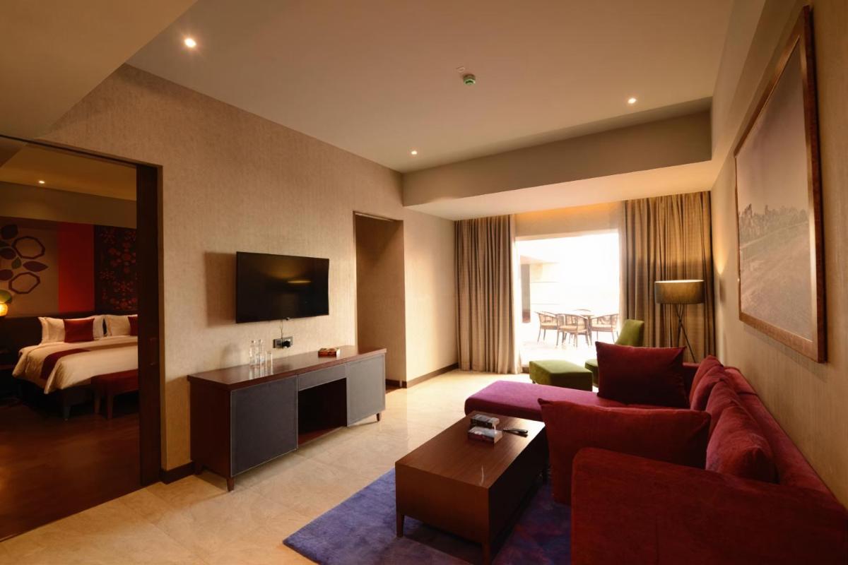 a living room with a couch and a bed at Grand Mercure Bengaluru at Gopalan Mall - An Accor Brand in Bengaluru a living room with a couch and a bed at Grand Mercure Bengaluru at Gopalan Mall - An Accor Brand in Bengaluru
