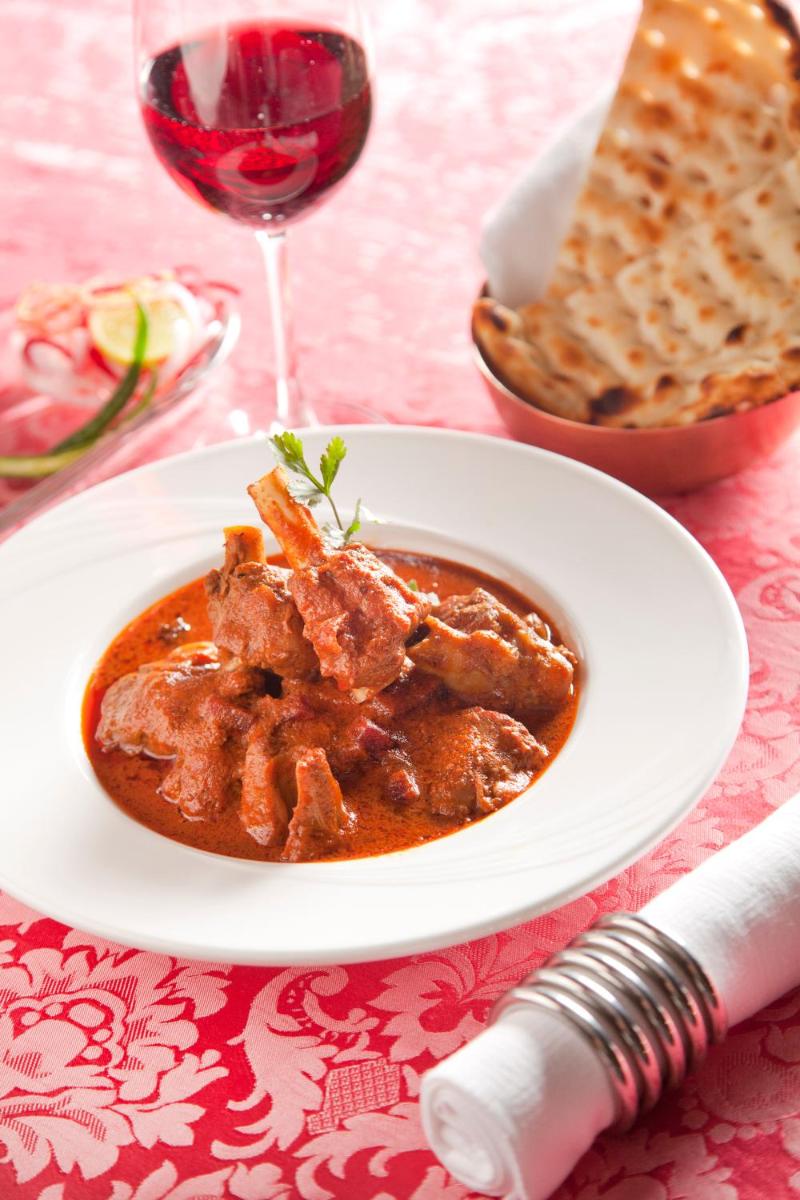 a plate of food on a table with a glass of wine at Crowne Plaza New Delhi Rohini by IHG in New Delhi a plate of food on a table with a glass of wine at Crowne Plaza New Delhi Rohini by IHG in New Delhi