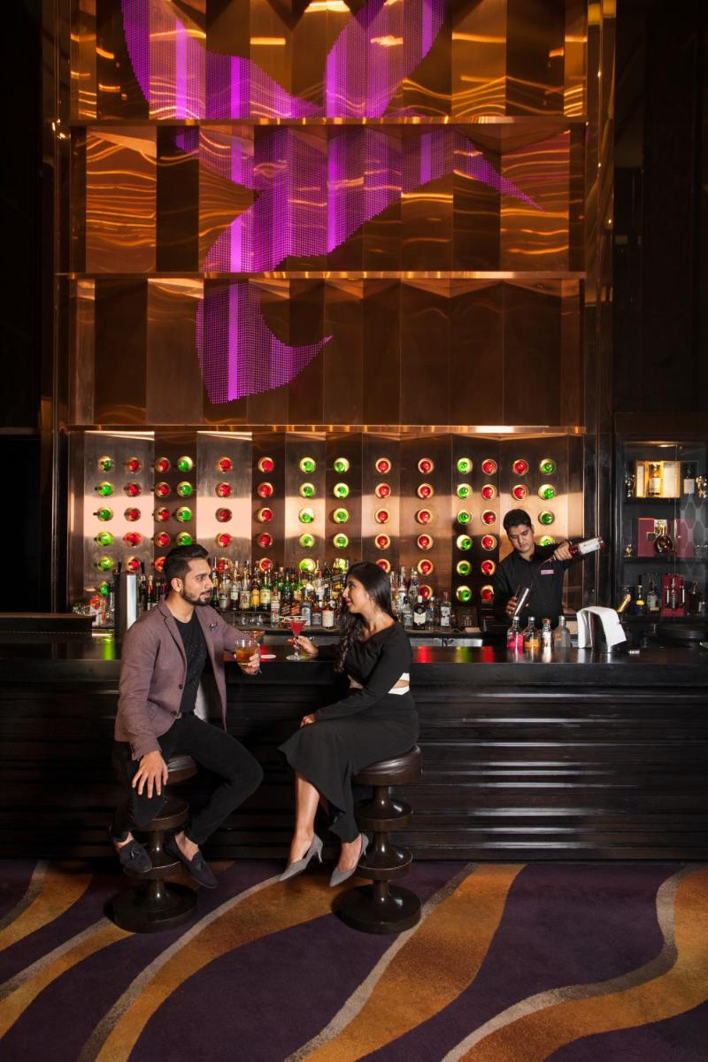 a man and a woman sitting at a bar at Crowne Plaza New Delhi Rohini by IHG in New Delhi a man and a woman sitting at a bar at Crowne Plaza New Delhi Rohini by IHG in New Delhi