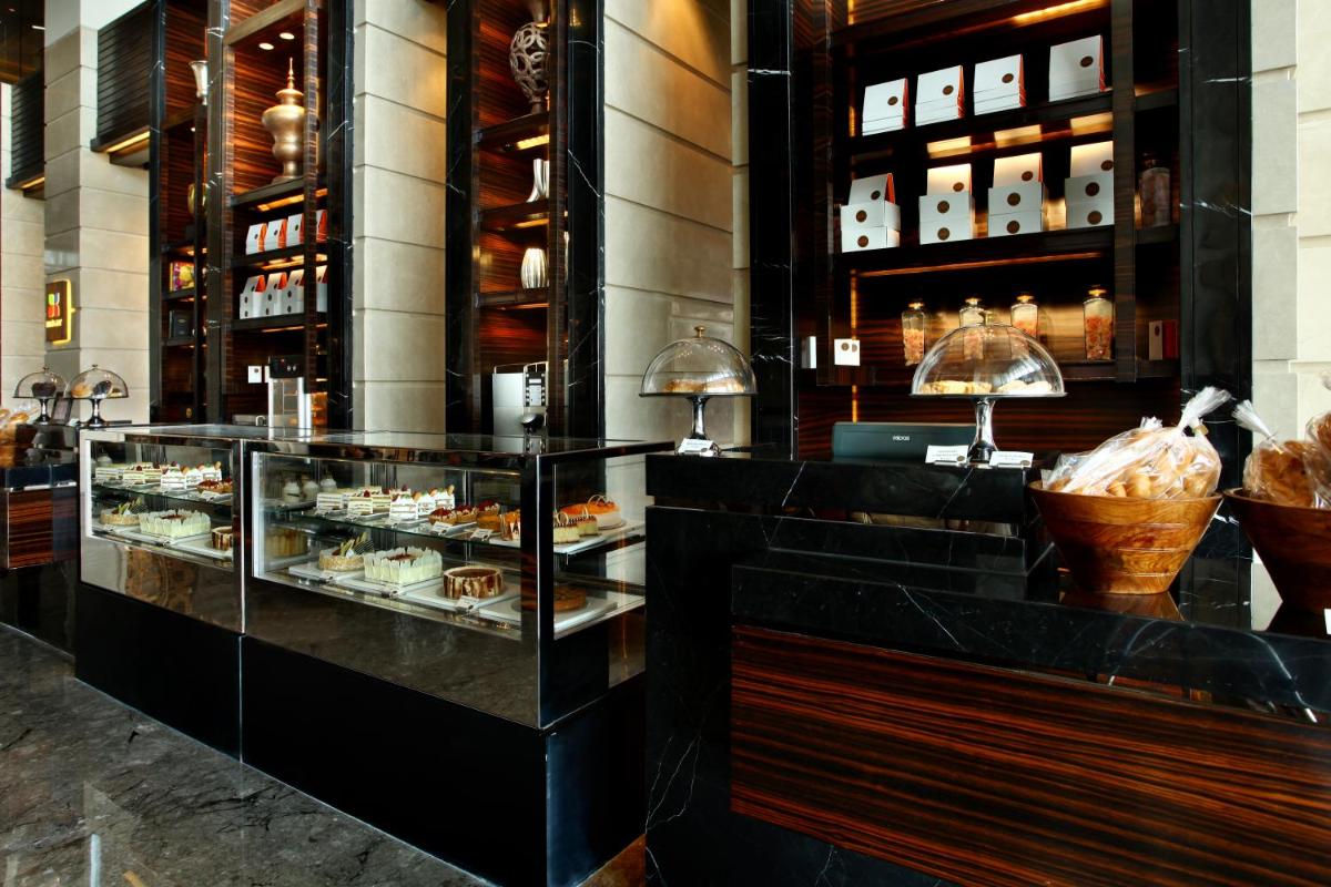 a restaurant with a display case filled with pastries at Crowne Plaza New Delhi Rohini by IHG in New Delhi a restaurant with a display case filled with pastries at Crowne Plaza New Delhi Rohini by IHG in New Delhi