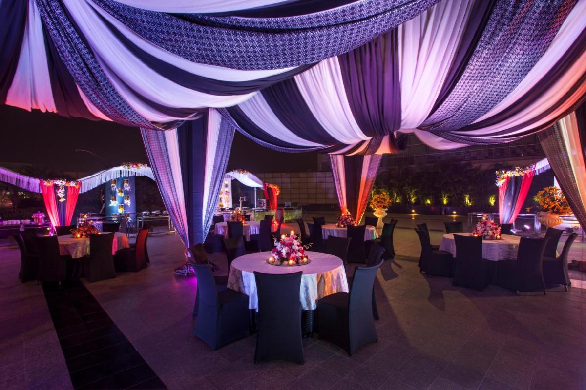 a set up for a party with tables and chairs at Crowne Plaza New Delhi Rohini by IHG in New Delhi a set up for a party with tables and chairs at Crowne Plaza New Delhi Rohini by IHG in New Delhi