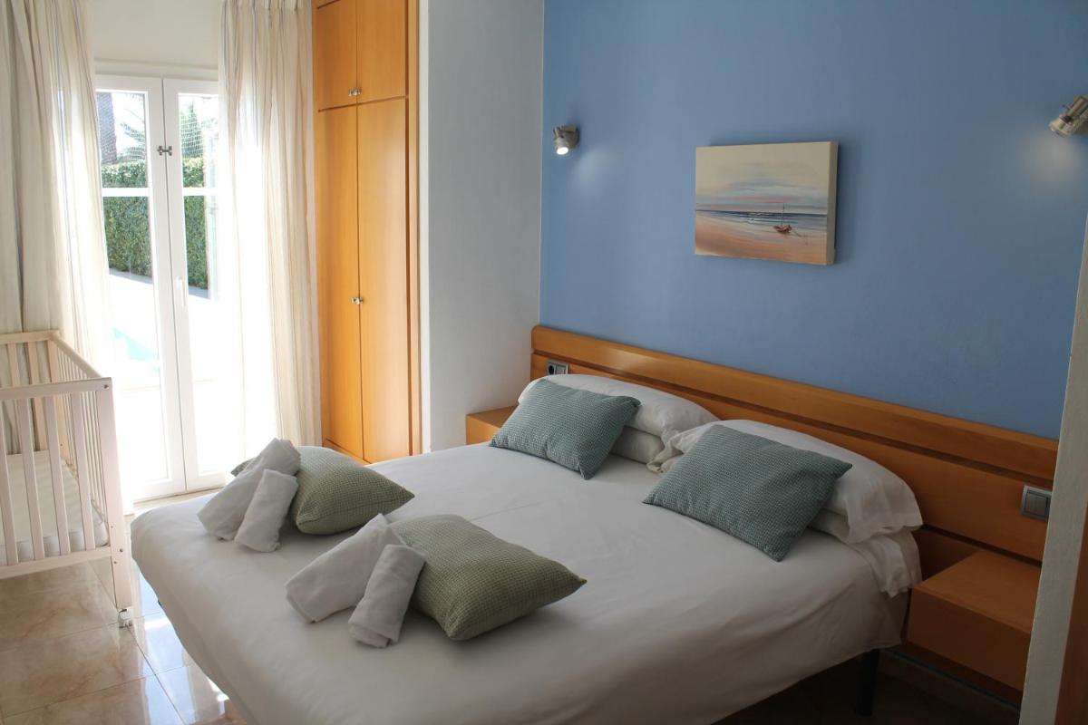 Un dormitorio con una cama con cuatro almohadas encima. en Apartaments Talayot, en Cala en Blanes 60 fotos más