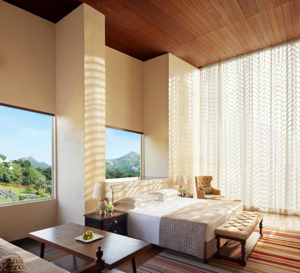 a bedroom with a large bed and a large window at Taj Aravali Resort & Spa Udaipur in Udaipur