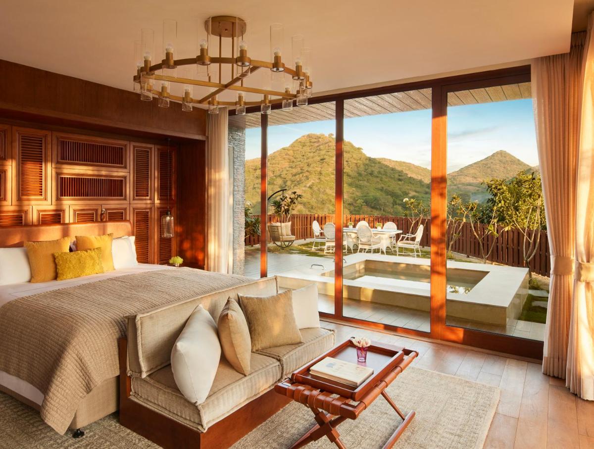 a bedroom with a bed and a large window at Taj Aravali Resort & Spa Udaipur in Udaipur