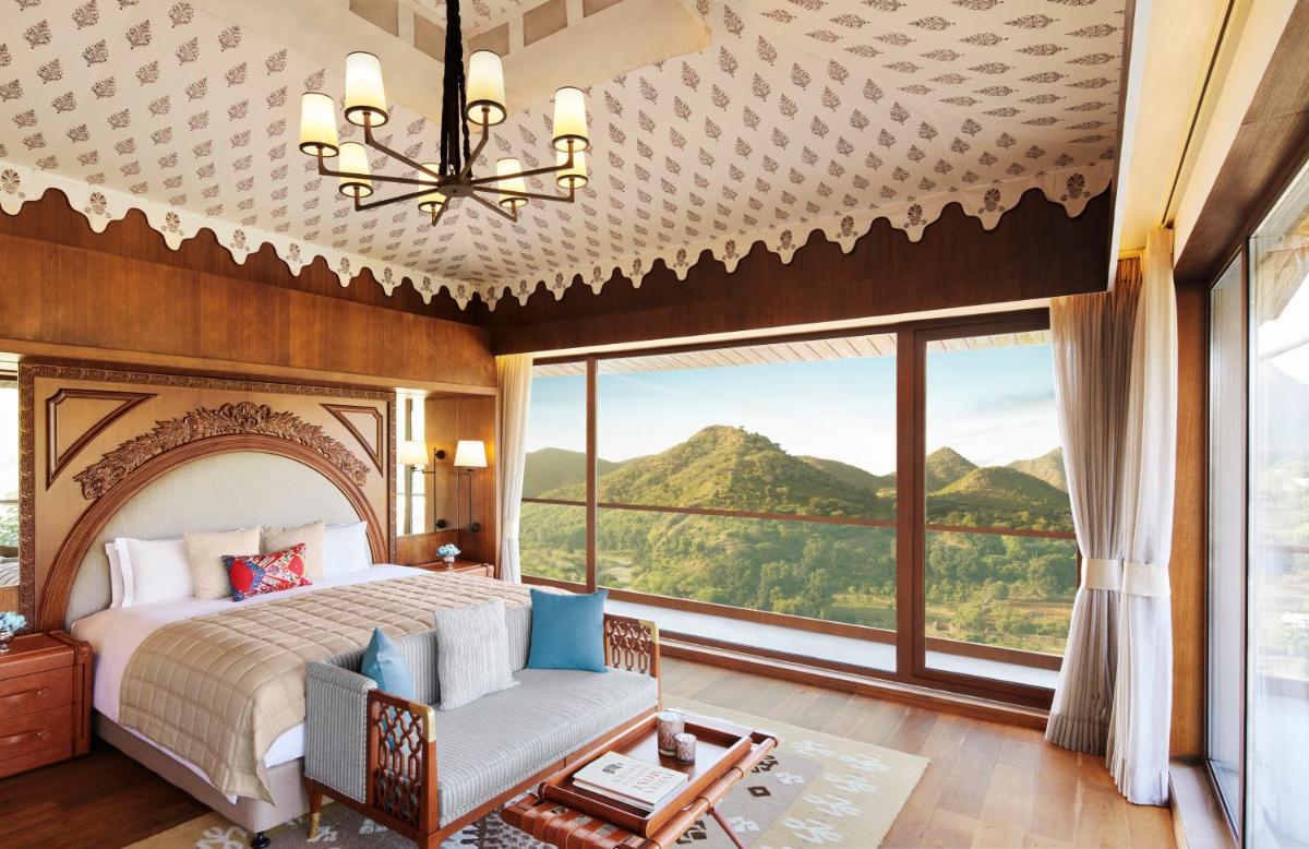 a bedroom with a bed and a large window at Taj Aravali Resort & Spa Udaipur in Udaipur