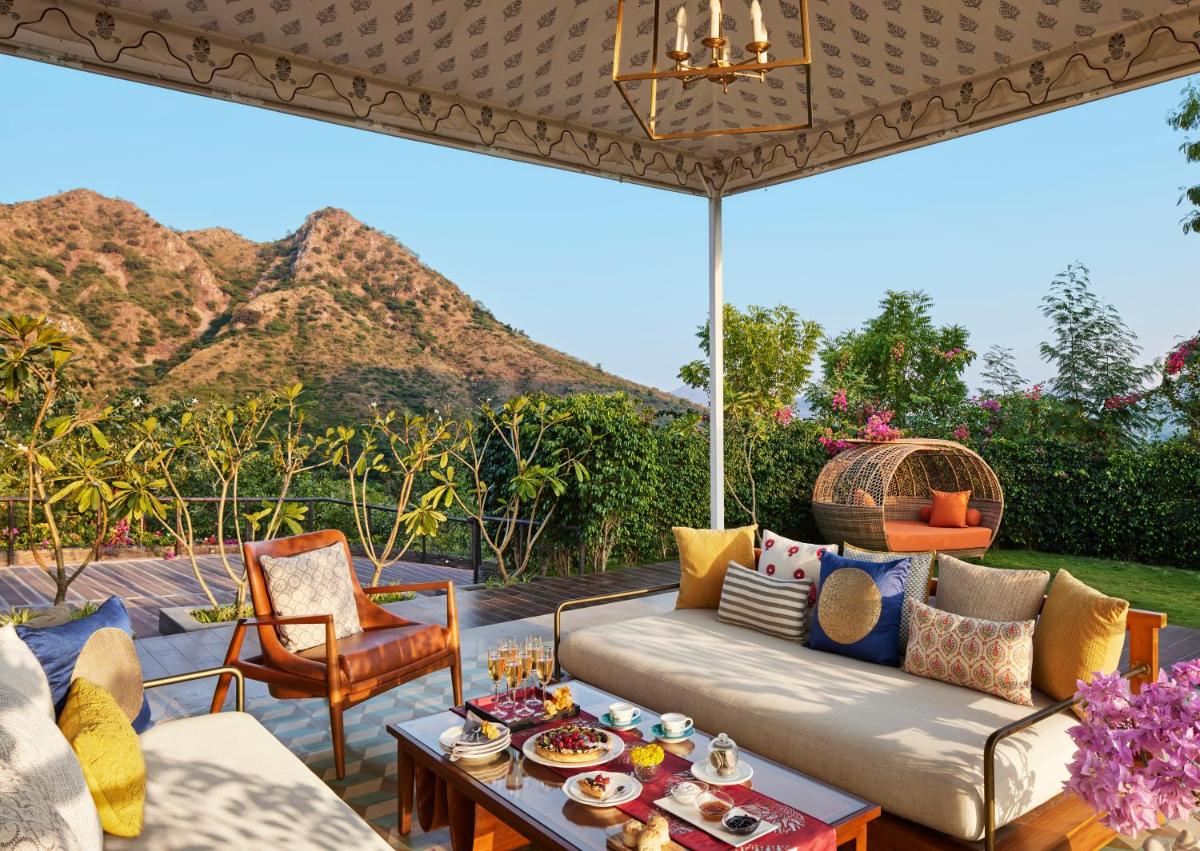a patio with a couch and table with a view of mountains at Taj Aravali Resort & Spa Udaipur in Udaipur