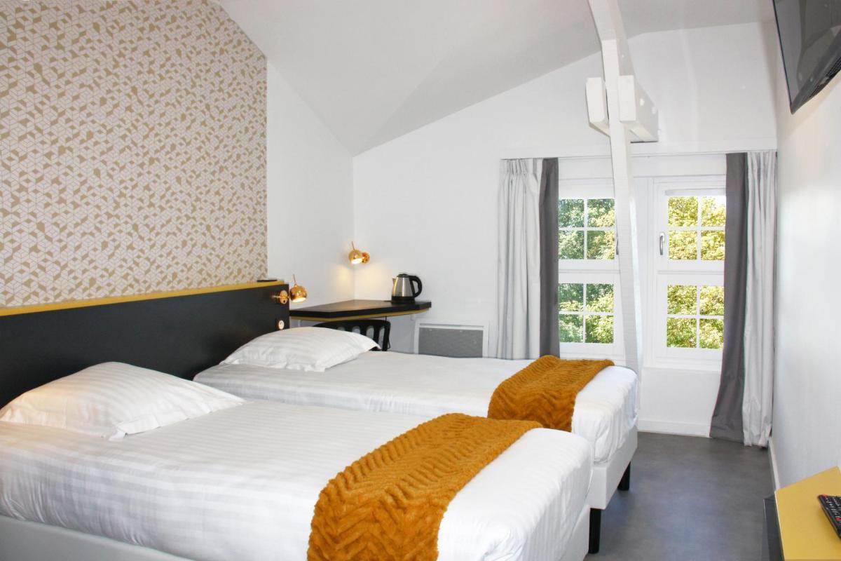 deux lits dans une chambre avec une fenêtre dans l'établissement Hôtel du Parc & Spa, à Hossegor