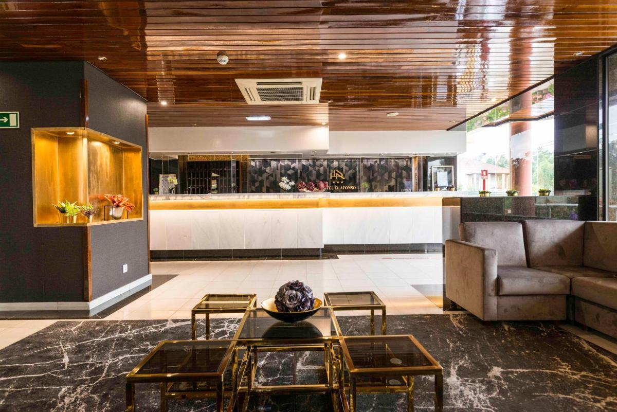 um átrio com um sofá e uma mesa em D. Afonso Hotel & SPA em Monte Real