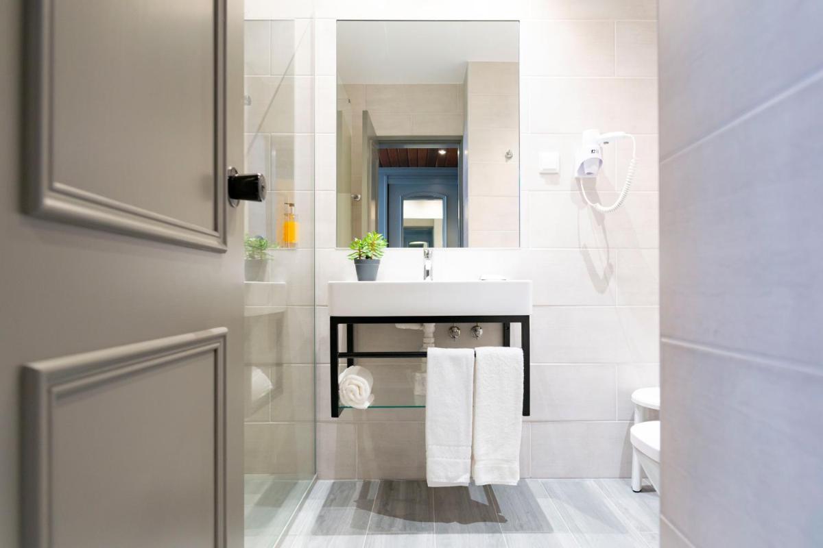 um banheiro com uma pia branca e um vaso sanitário em D. Afonso Hotel & SPA em Monte Real