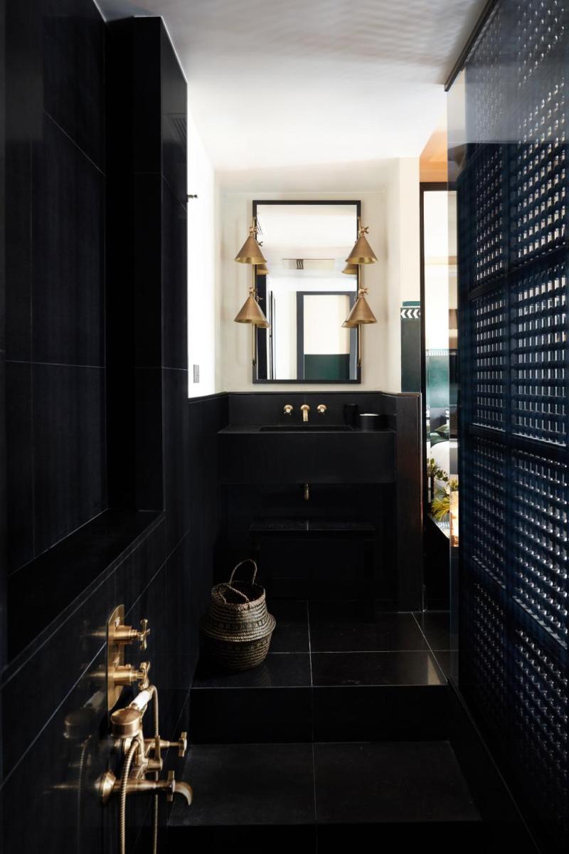 une salle de bain noire avec un lavabo et un miroir dans l'établissement Monsieur George Hotel & Spa - Champs-Elysées, à Paris 148 autres photos