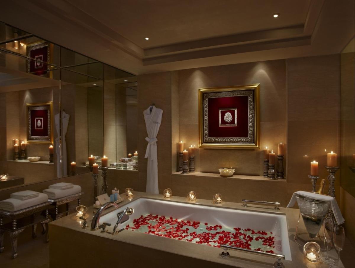 a bathroom with a tub filled with red roses at The Leela Palace Udaipur in Udaipur