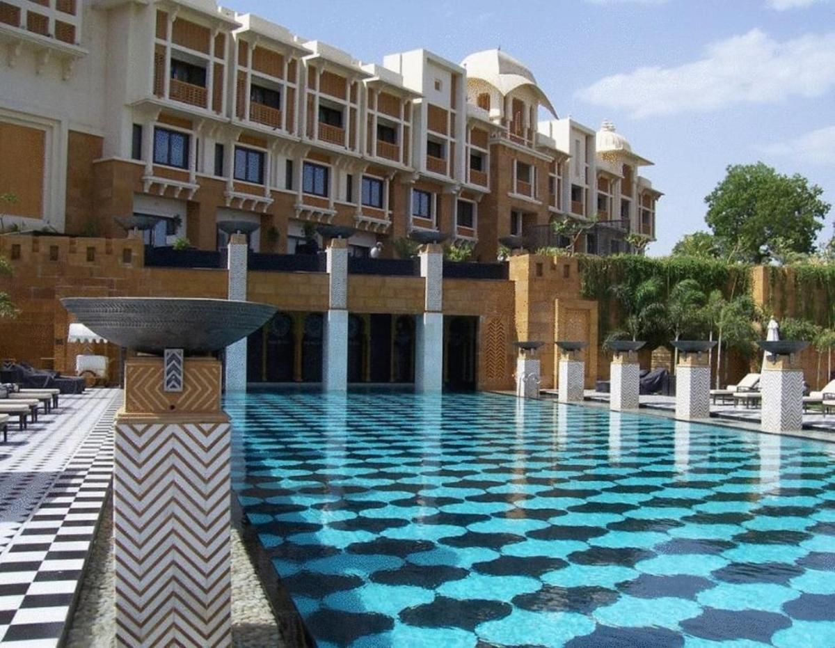 a swimming pool in front of a building at The Leela Palace Udaipur in Udaipur