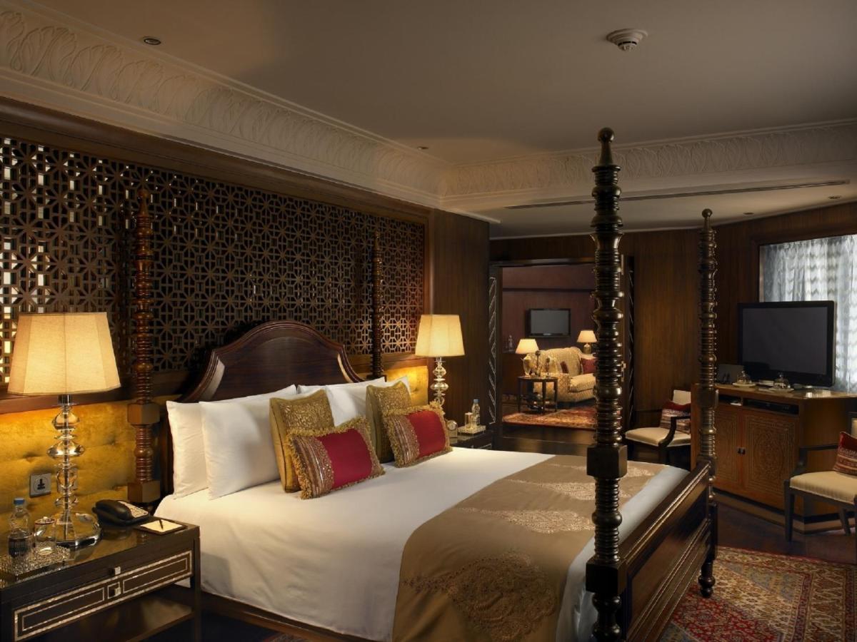 a bedroom with a large bed and a television at The Leela Palace Udaipur in Udaipur