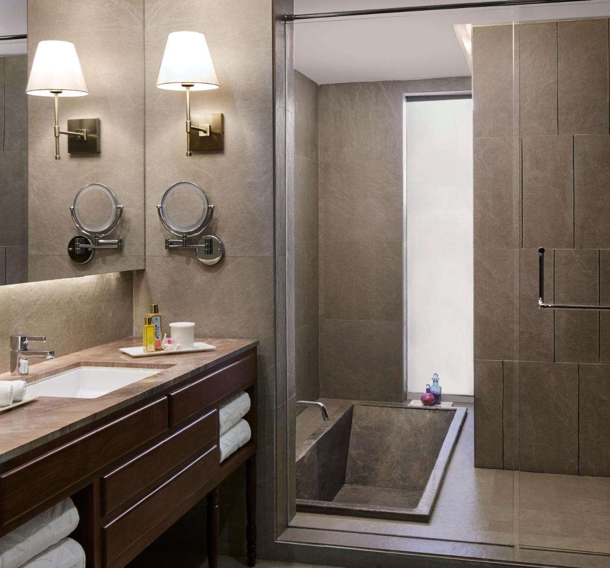 a bathroom with a shower and a sink and a tub at Taj Aravali Resort & Spa Udaipur in Udaipur