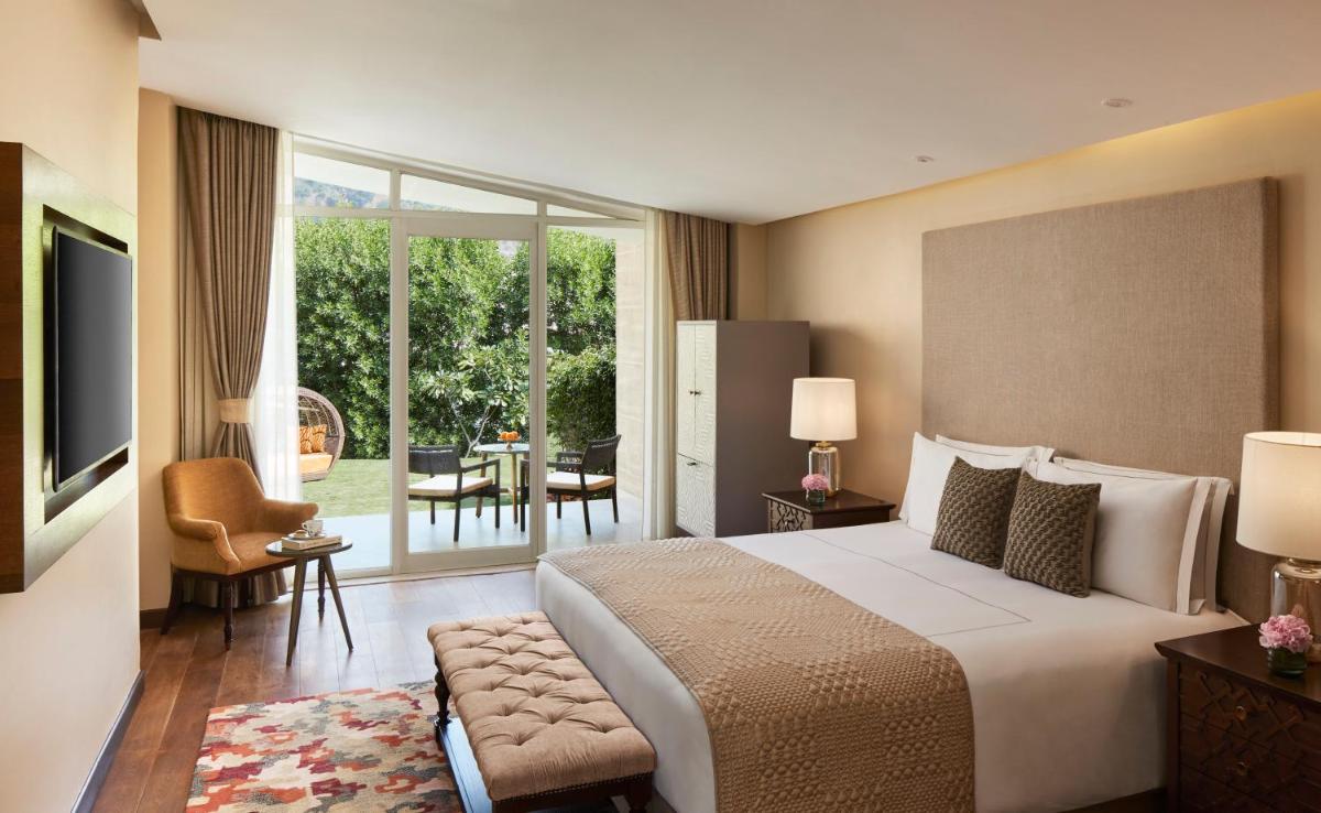 a bedroom with a large bed and a living room at Taj Aravali Resort & Spa Udaipur in Udaipur