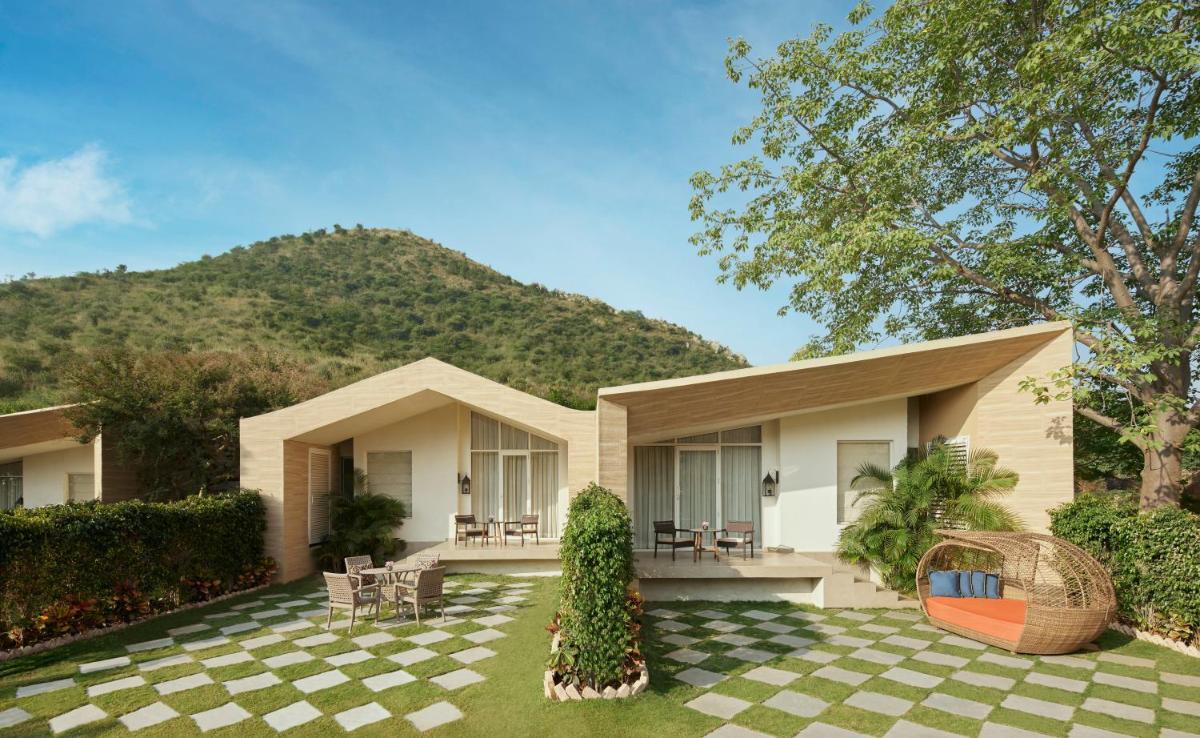 a house with a mountain in the background at Taj Aravali Resort & Spa Udaipur in Udaipur