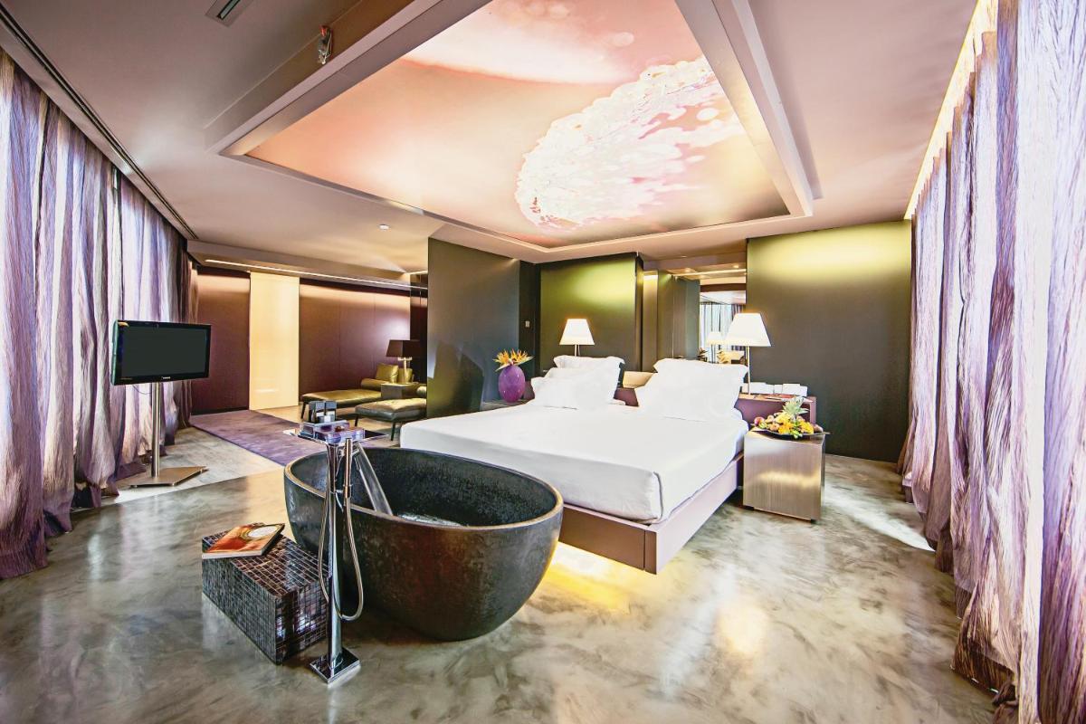 um quarto de hotel com uma cama e uma banheira em The Vine Hotel no Funchal