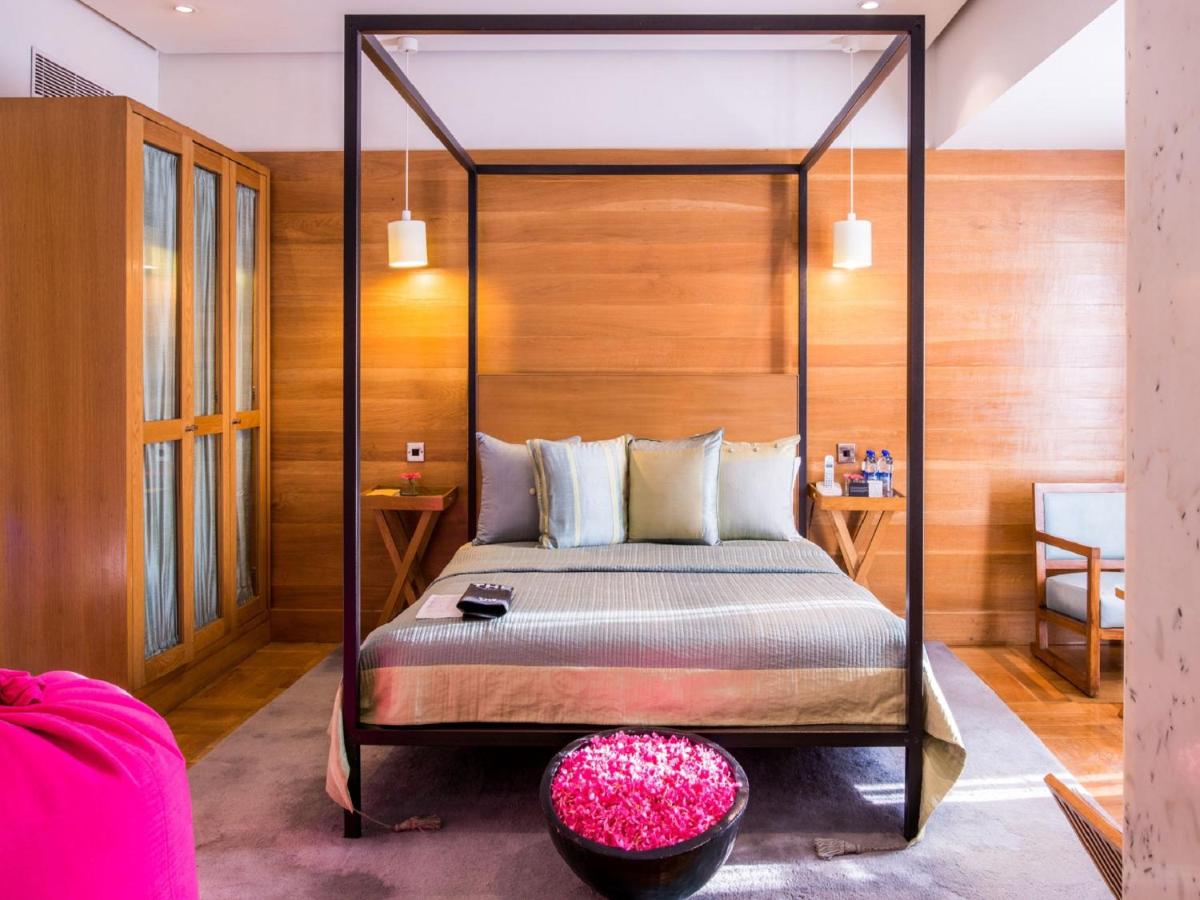 a bedroom with a four poster bed with a wooden wall at The Park Bangalore, MG Road in Bengaluru a bedroom with a four poster bed with a wooden wall at The Park Bangalore, MG Road in Bengaluru