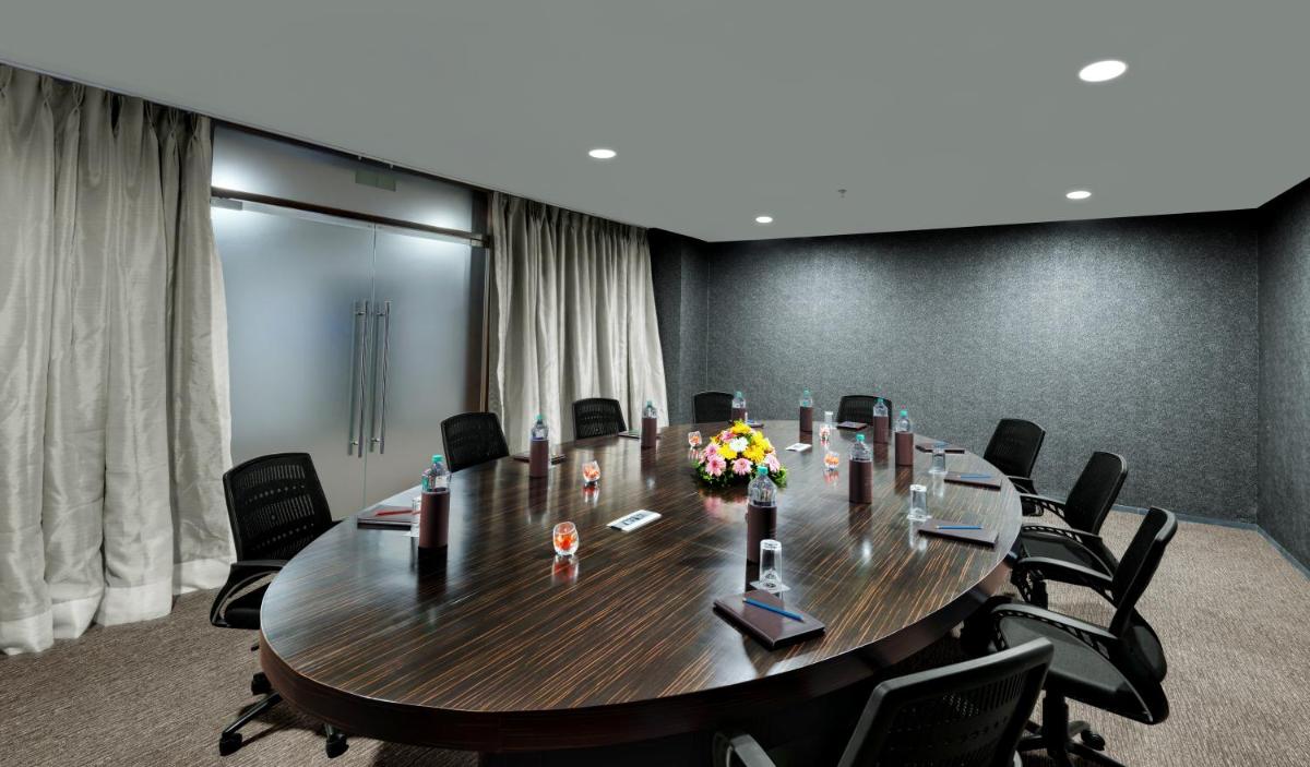 a conference room with a large wooden table and chairs at Wyndham Ahmedabad Shela in Ahmedabad